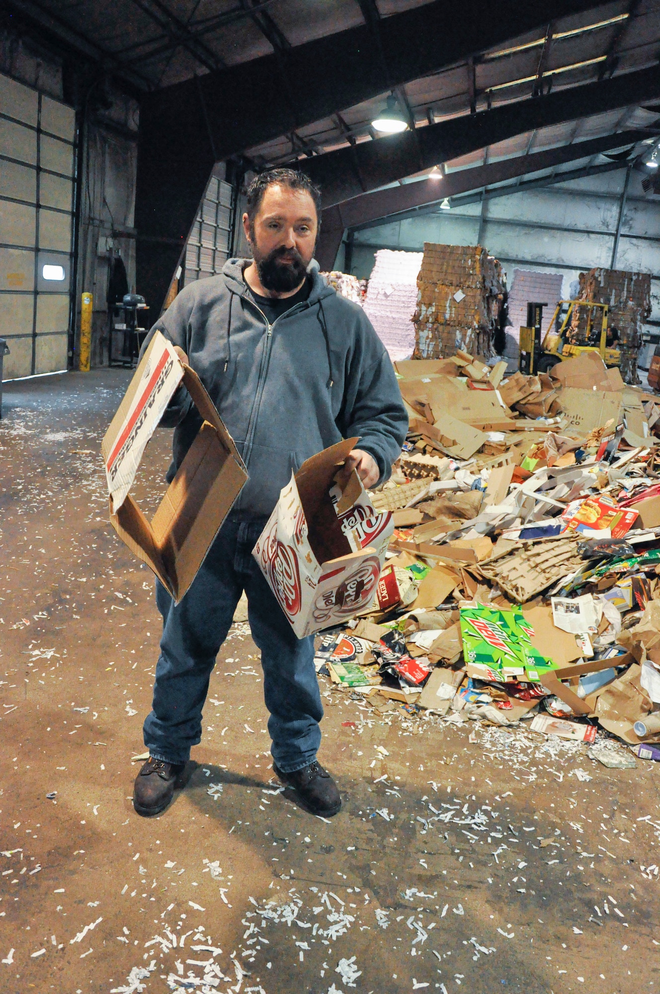 Thom Doucette, operations manager for the Wright-Patt Recycling Center shows us the difference between heavy mix – flat cardboard such as soda, donut, and cereal boxes – and the more valuable corrugated cardboard. The materials need to separated at the source to reduce manpower sorting costs. (U.S. Air Force photo/Gene Barnett)