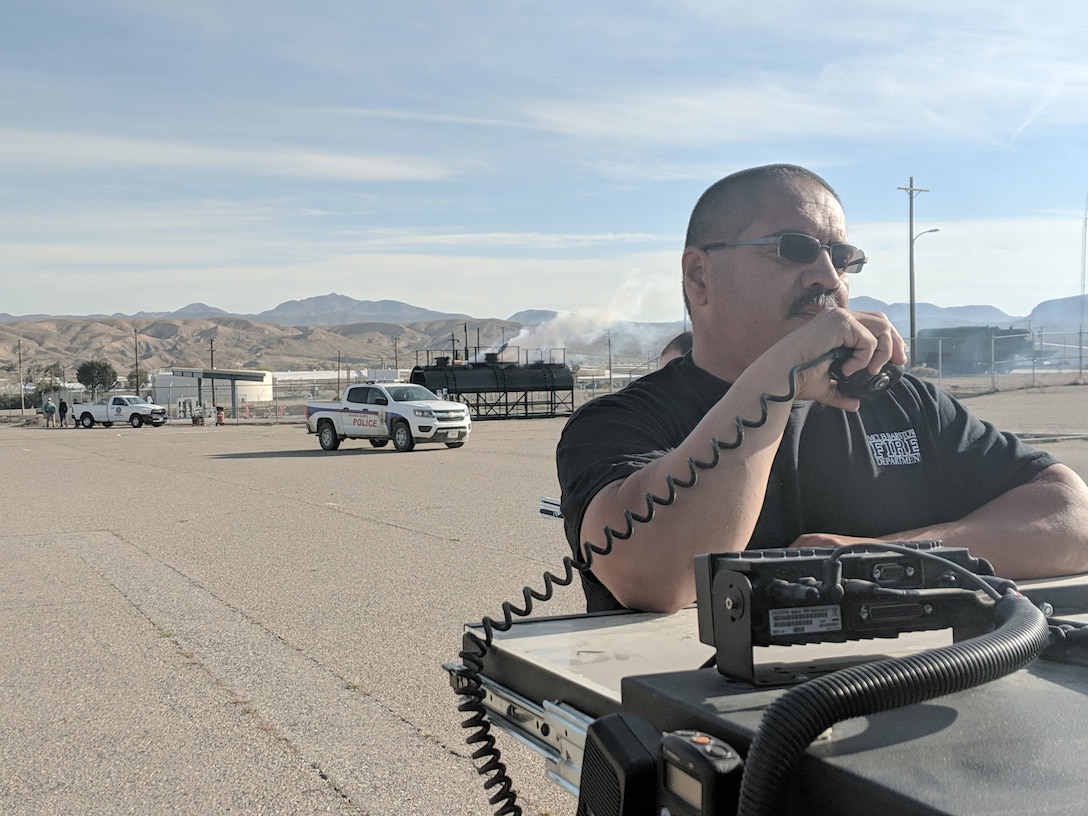 Domingo Duran, Assistant Fire Chief, MCLBB Fire and Emergency Services Division, reports simulated rail tanker car gas leak during Exercise Haber Rail aboard Marine Corps Logistics Base Barstow, Calif., March 19.