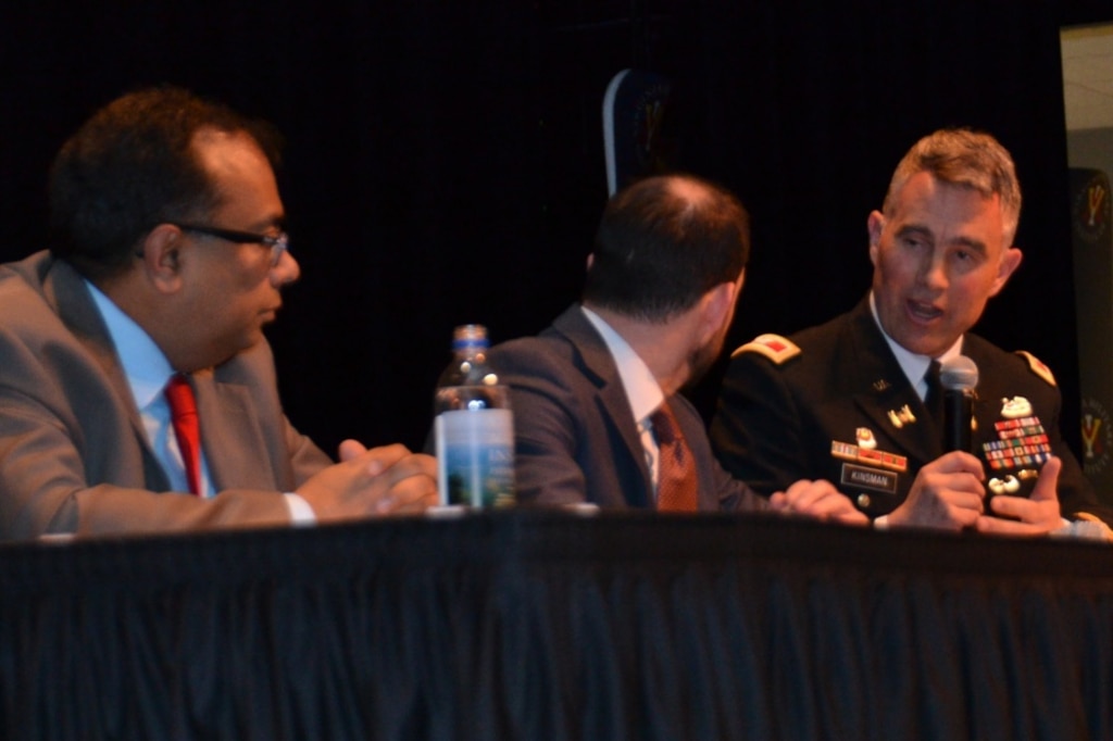 Three men sitting on a discussion panel at table