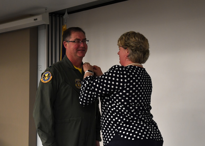 Lt. Col. Bryan Branby, chief of the 911th Airlift Wing Program Integration Office, receives his retirement pin from Laura Branby, his wife, at the Pittsburgh International Airport Air Reserve Station, Pennsylvania, March 22, 2019. Branby said his family have been there to support him throughout his career and he is glad there could be there to support him in his retirement as well. (U.S. Air Force photo by Senior Airman Grace Thomson)