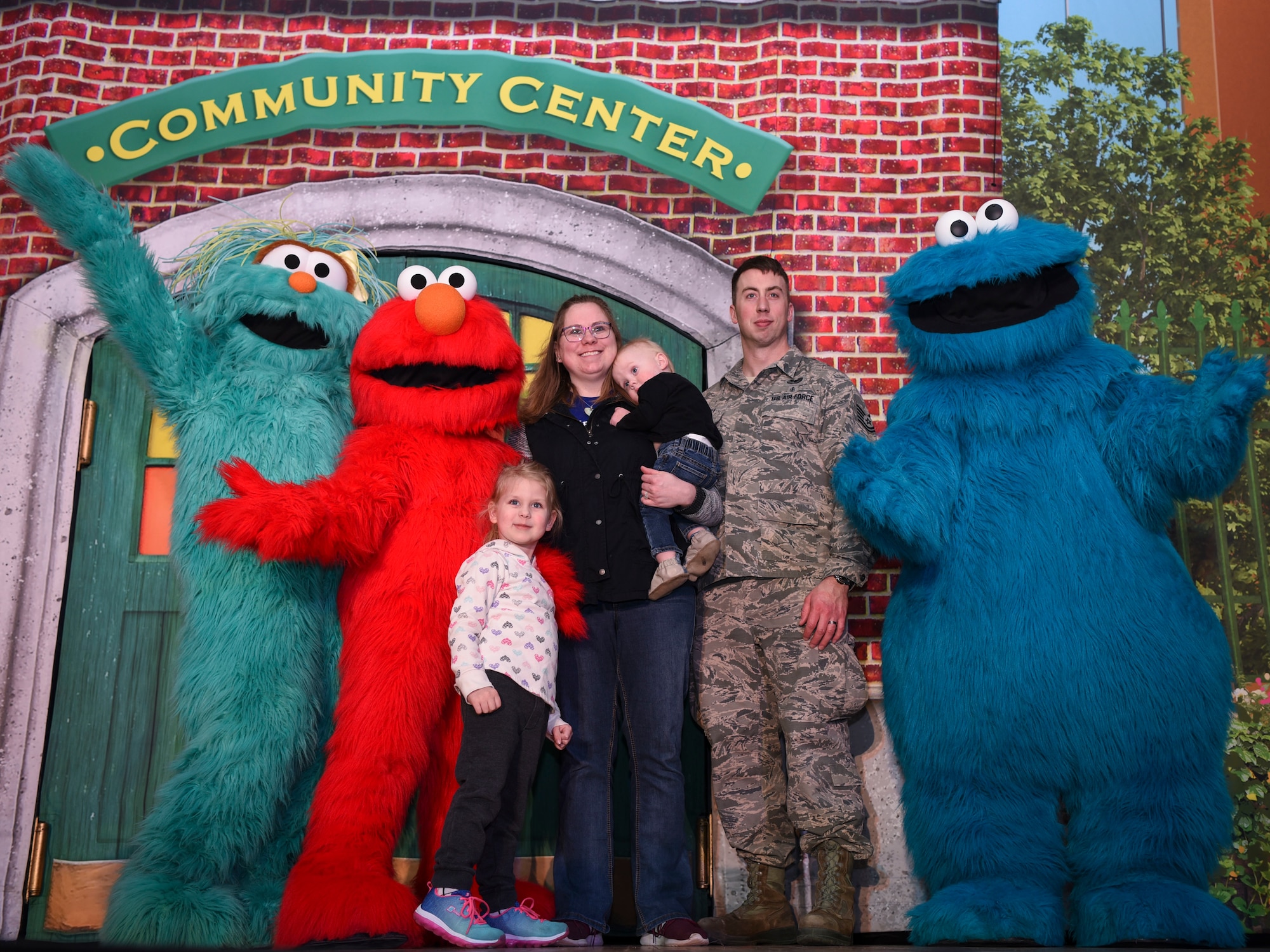 A Grand Forks Air Force Base family poses for a photo beside cast members during a meet and greet with the “Sesame Street Live” cast on March 26, 2019, on Grand Forks Air Force Base, North Dakota. The meet and greet allowed families in attendance the chance to meet the characters prior to a performance of dance and song, which emphasized the importance of kindness in a community. (U.S. Air Force photo by Airman 1st Class Melody Wolff)