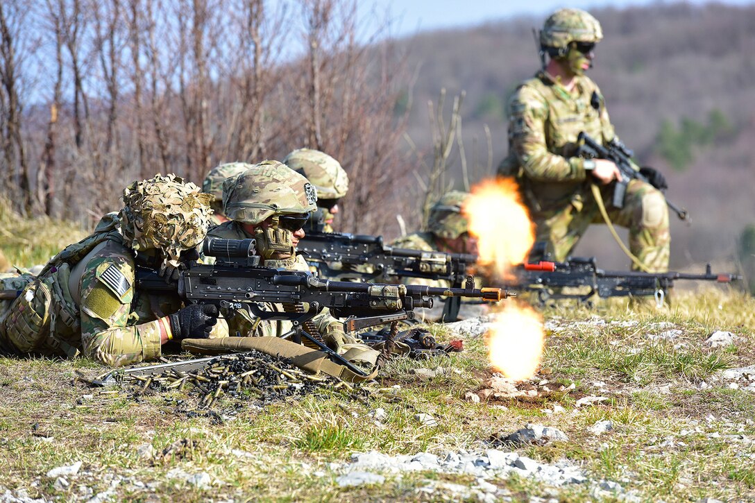 Service members fire at targets.