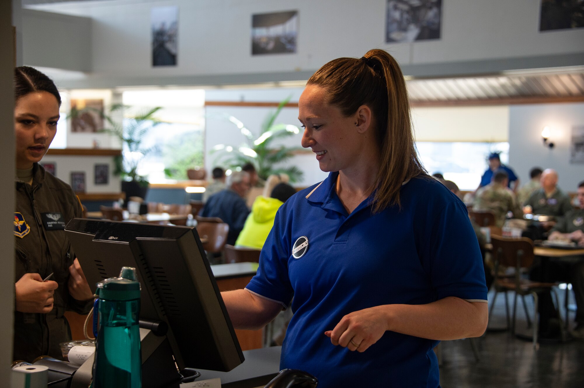 Brandi Spriggs, a cashier contractor, takes the meal card of a customer, March 26, 2019, at Altus Air Force Base, Okla. At Hangar 97, Airmen both in the dorms and going through initial training receive meal cards to pay for their food. (U.S. Air Force photo by Senior Airman Cody Dowell)