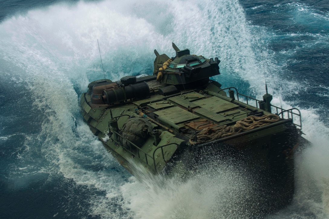 An assault amphibious vehicle splashes in water.