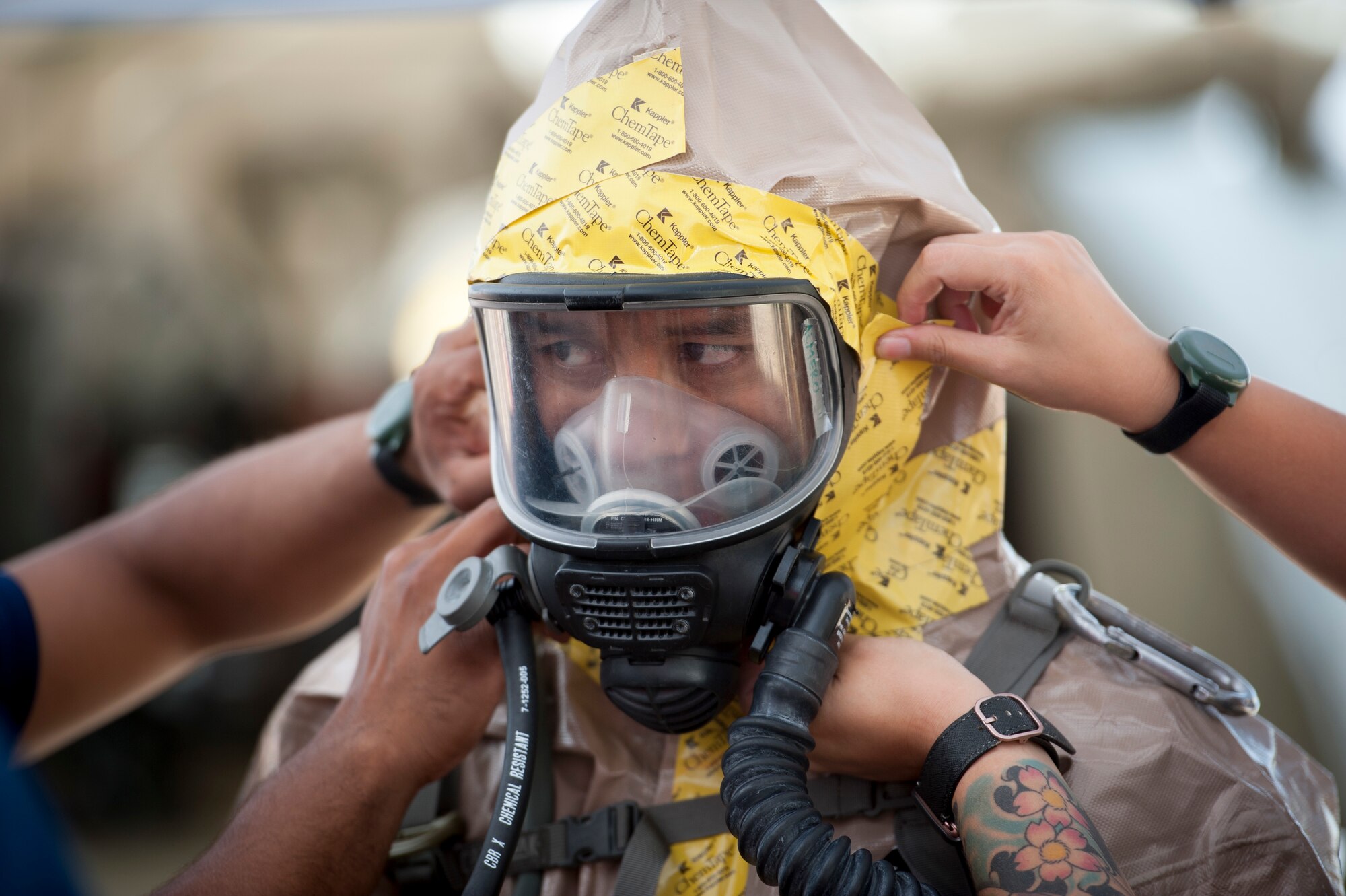 Staff Sgt. James Almero, 154th Medical Group Det. 1 all-hazards-triage-response team member, receives assistance in donning personal protective equipment prior to his rotation into the ‘Hot Zone’ March 9, 2019, at Kalaeloa, Hawaii.