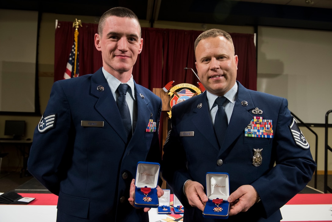 U.S. Air Force Staff Sgt. Tyler Ferris, 92nd Maintenance Group Air Force Repair Enhance Program technician and U.S. Air Force Master Sgt. Blaine Holland, 92nd Civil Engineer Squadron Fire Emergency Services superintendent receive a life-saving award from the Spokane Fire Department at the Spokane Fire Department Training Facility in Spokane, Washington, March 27, 2019. Ferris and Holland provided life-saving first-aid to the victim of a car accident. (U.S. Air Force photo by Airman 1st Class Lawrence Sena)