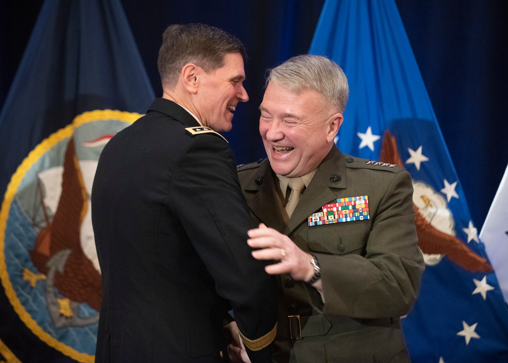 Army Gen. Joseph L. Votel embraces Marine Corps Gen. Frank McKenzie, incoming commander of U.S. Central Command, during a change of command ceremony in Tampa, Florida, March 28, 2019. McKenzie previously served as the director of the Joint Staff.