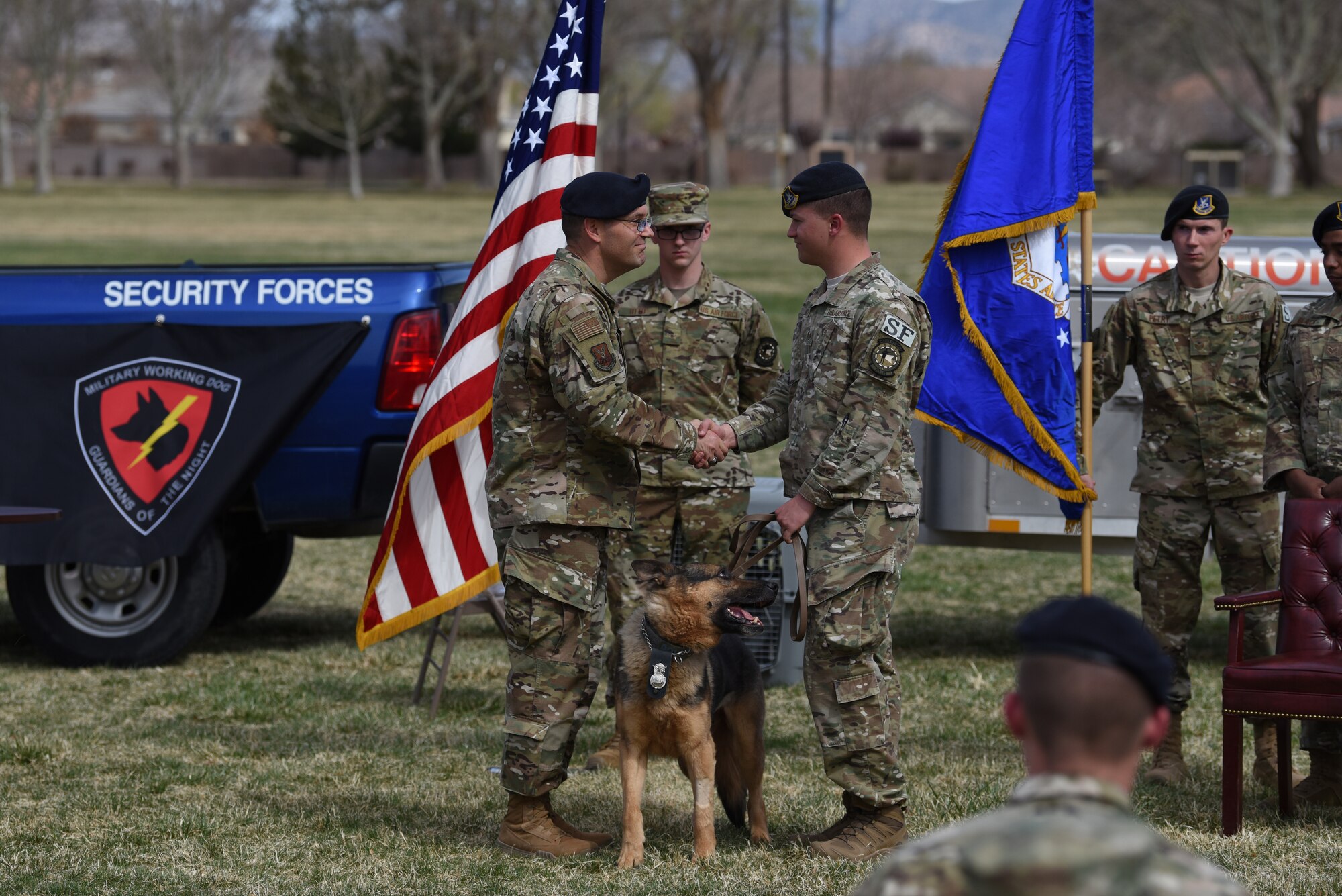 U.S. Air Force Col. Theodore Breuker, 377th Security Forces Group commander, hands over responsibility of Military Working Dog Boris to Staff Sgt. Austin Clark, 377th Security Forces Squadron military working dog handler and Boris’s adopter, at Kirtland Air Force Base N.M., March 26, 2019. Boris had 10 handlers during his career, and worked with Clark for two of his eight years in service. (U.S. Air Force photo by Senior Airman Eli Chevalier)