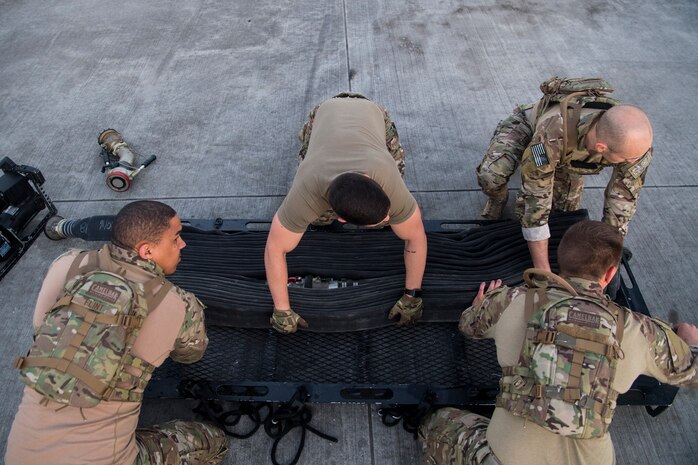 Airmen from the 628th Logistics Readiness Squadron fuels management flight re-pack a hose during a forward area refueling point team tryout March 26, 2019, at Joint Base Charleston, S.C.