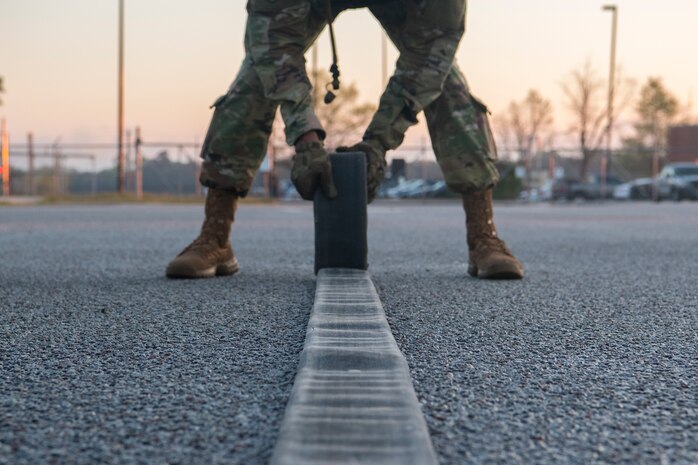 Chief Master Sgt. Todd Cole, 628th Air Base Wing command chief, rolls a refueling hose during a forward area refueling point team tryout March 26, 2019, at Joint Base Charleston, S.C.