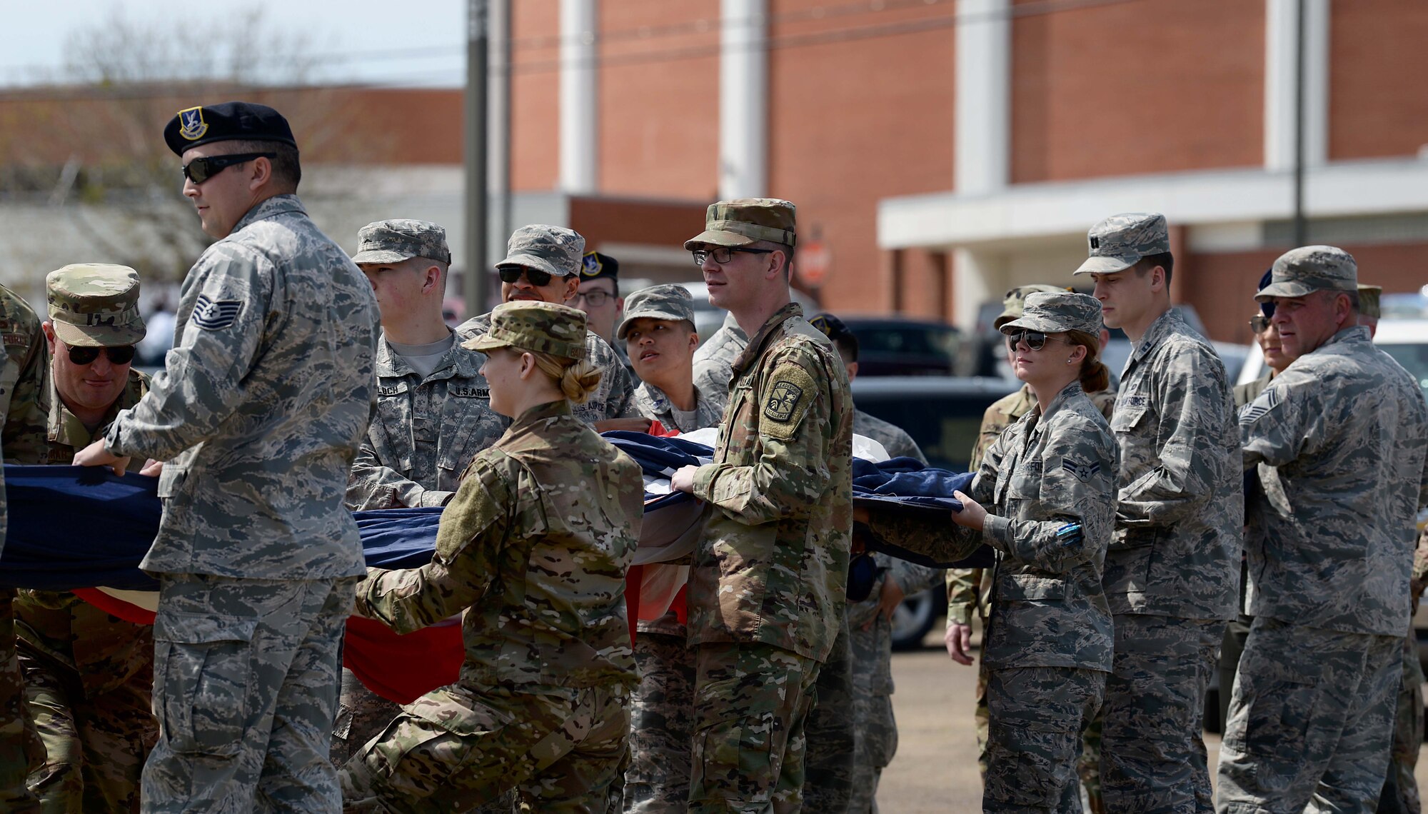 Military members practice unfurling the flag at Mississippi State University March 23, 2019, in Starkville, Mississippi. Nearly 100 members volunteered to present the flag during MSU’s “Salute to Service” military recognition before the game. (U.S. Air Force photo by Airman Hannah Bean)