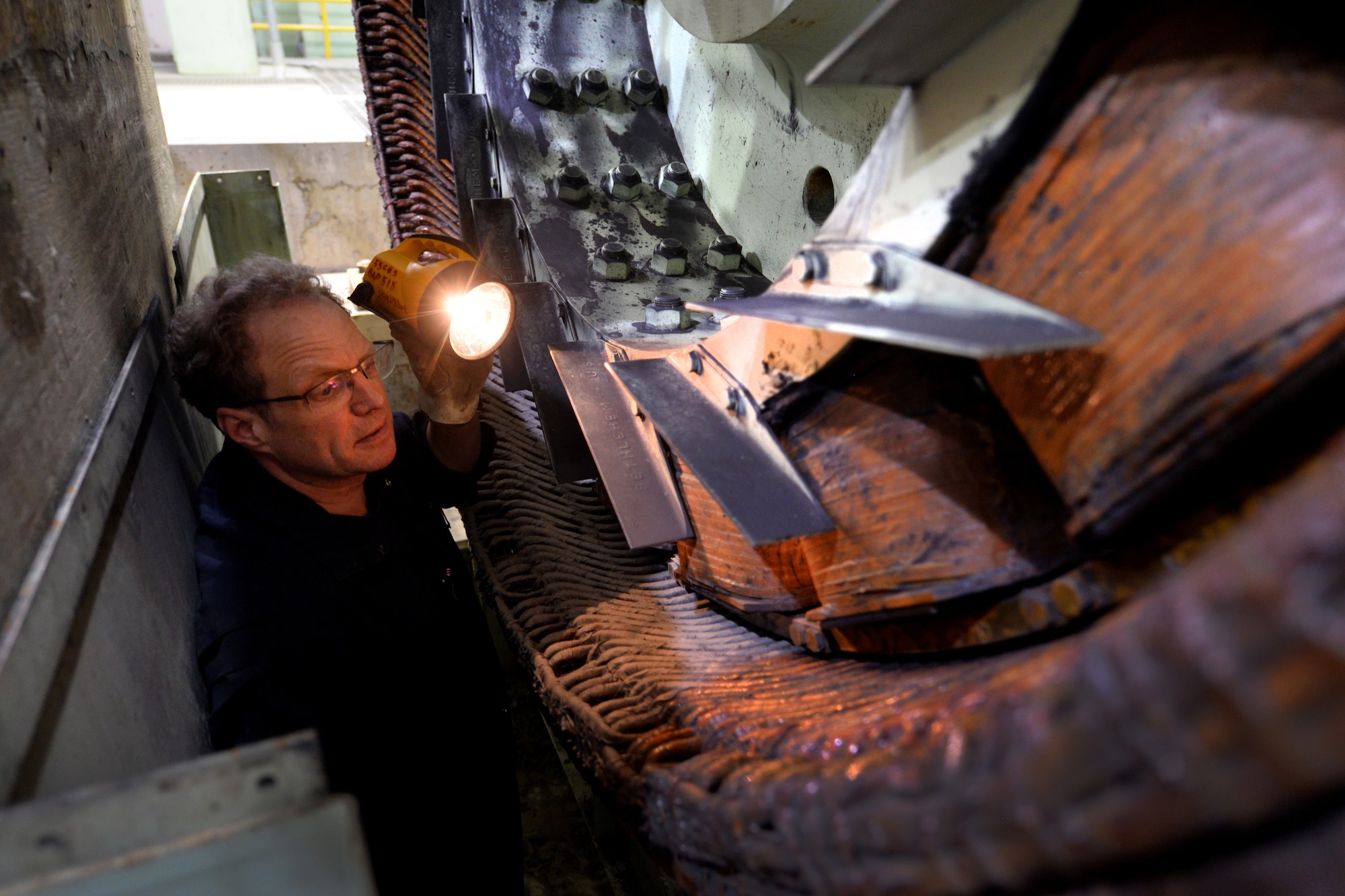 Dave Cormack, 55th Civil Engineer Squadron power support systems mechanic, inspects an alternator for flood damage on Offutt Air Force Base, Nebraska, March 28, 2019. The generators were partially submerged in flood waters following an inordinate amount of snowfall, in the midwest, coupled with several other factors resulted in record-flooding of the adjacent Missouri River.  (U.S. Air Force photo by Josh Plueger)