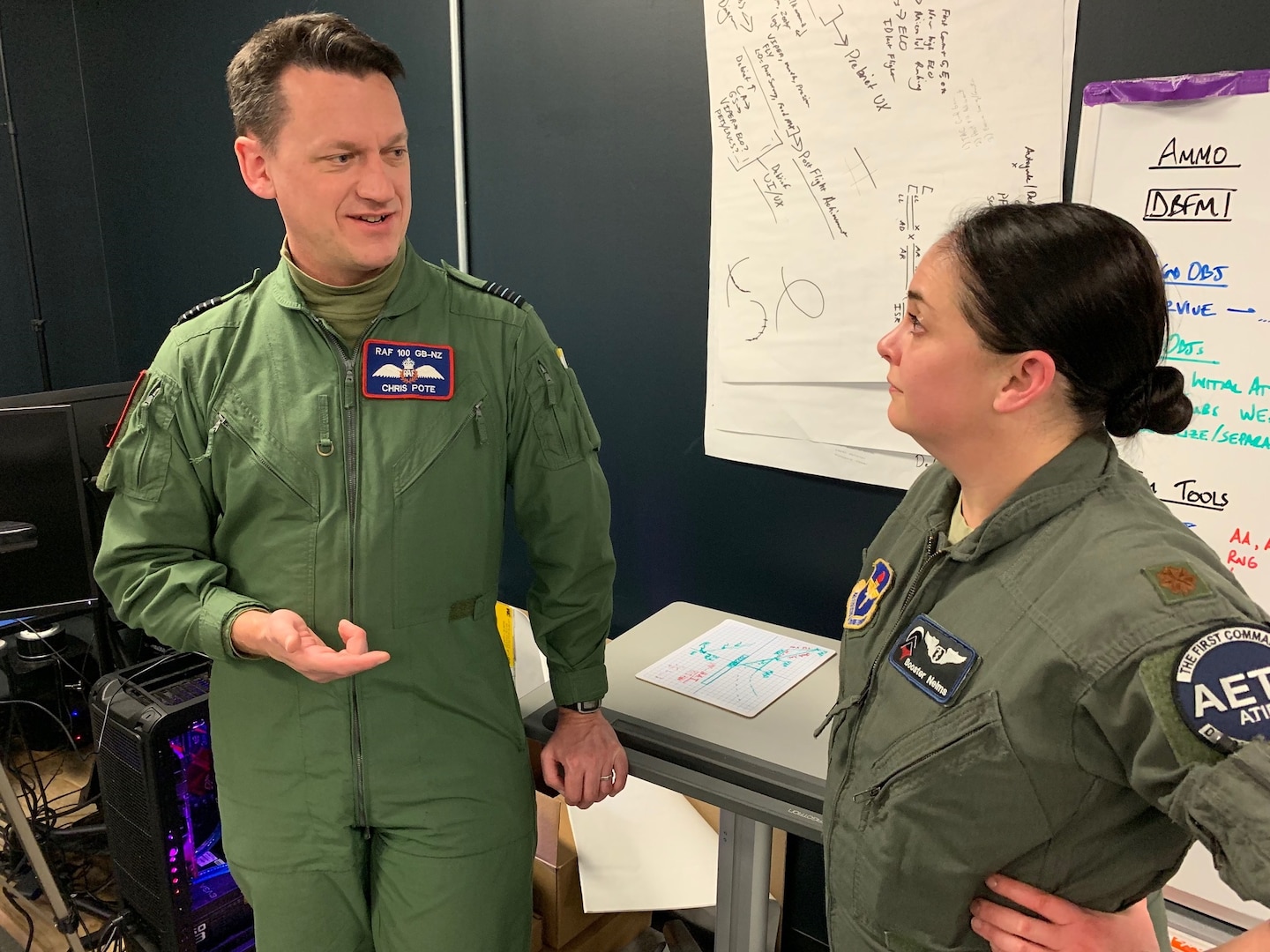 U.S. Air Force Maj. Joanna Nelms, Pilot Training Next 2.0 flight doctor from the 359th Medical Group, talks to Royal Air Force Wing Commander Christopher Pote, Headquarters 22 Group, at the PTN facility at the Armed Forces Reserve Center in Austin, Texas, March 18. The RAF is participating in PTN's second iteration in an effort to accelerate learning and increase pilot production.
