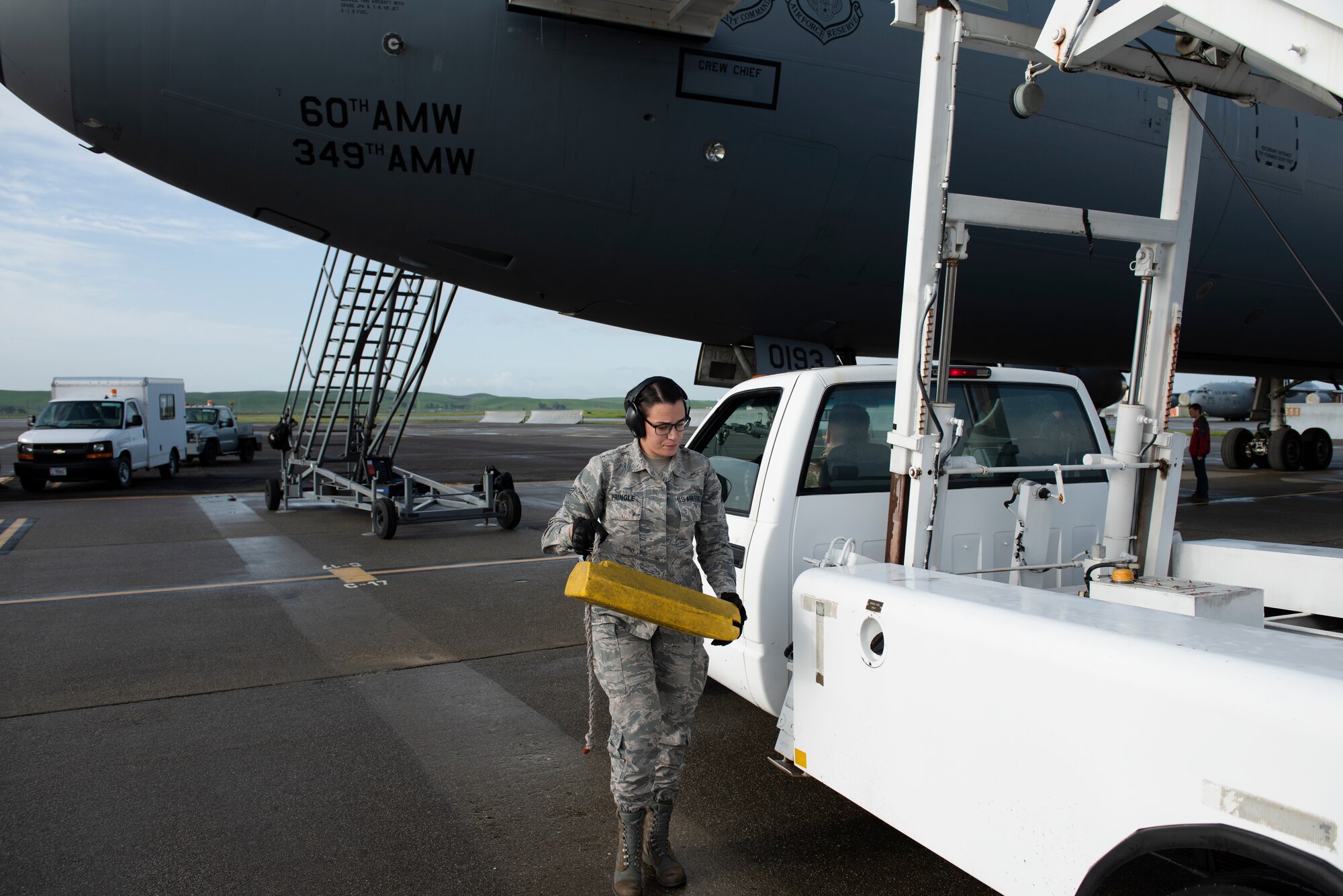 Senior Airman Kayleen Fringle, 60th Aerial Port Squadron passenger services agent, prepares to place a block at one of the back tires of a staircase truck to prevent it from moving once it’s parked outside a KC-10 Extender, March 28, 2019 at Travis Air Force Base, California. The staircase was used by passengers to enter and exit the aircraft. The KC-10, which flew a refueling mission in support of a Boeing E-3 Sentry and the A-10 Thunderbolt II, will be featured at the Thunder Over the Bay Air Show at Travis March 30-31. (U.S. Air Force photo by Tech. Sgt. James Hodgman)