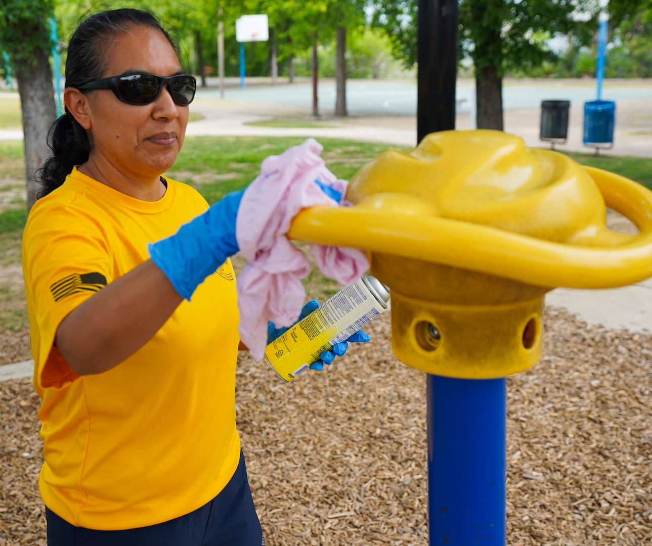 Chief Petty Officer Irene Aguilar, assigned to Navy Medicine Education, Training and Logistics Command at Joint Base San Antonio-Fort Sam Houston, disinfects parts of playground during a community relations event held at Martinez Park during a Sailor 360 event. Sailor 360 is a command-level program for junior enlisted, senior enlisted and junior officers designed to strengthen and develop leadership through COMREL events, classroom discussions and physical training events.