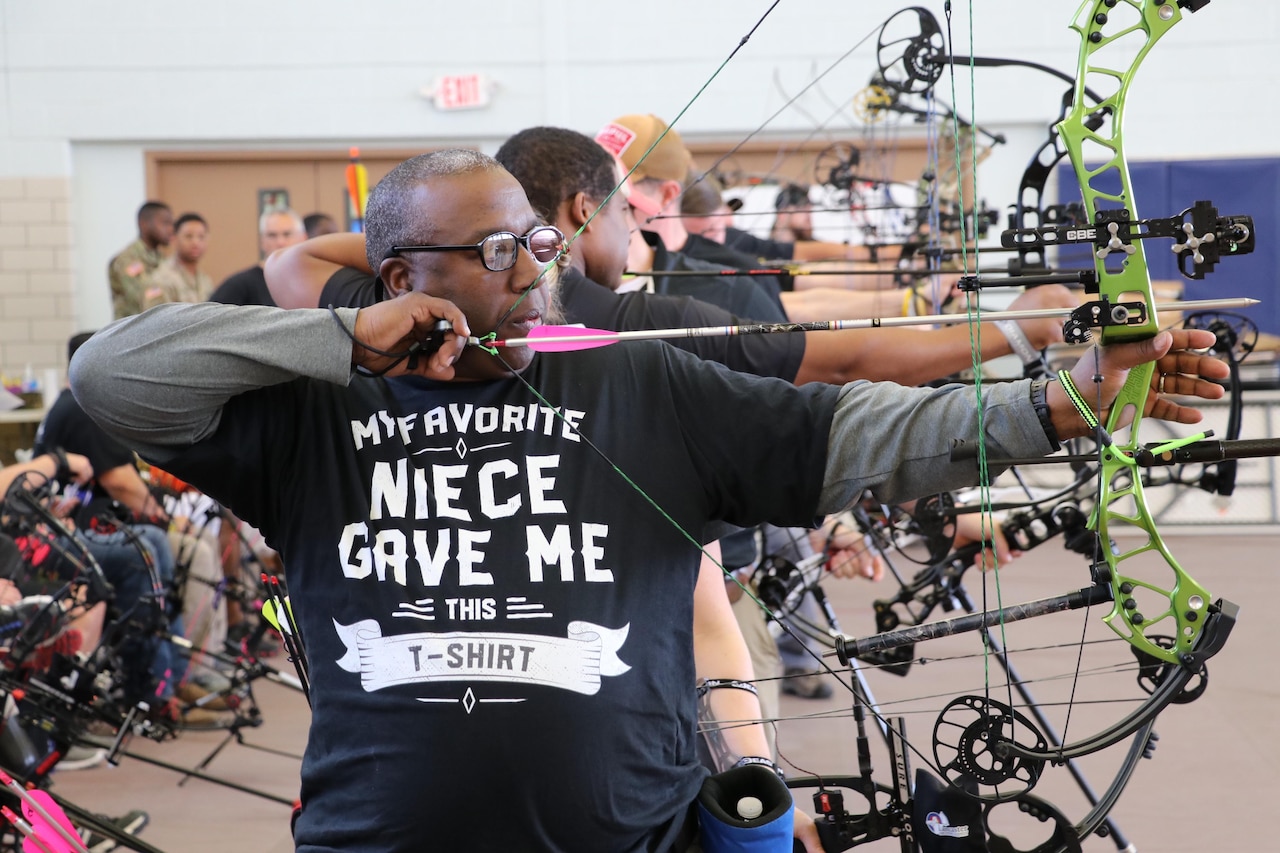 Man draws back on a compound bow.