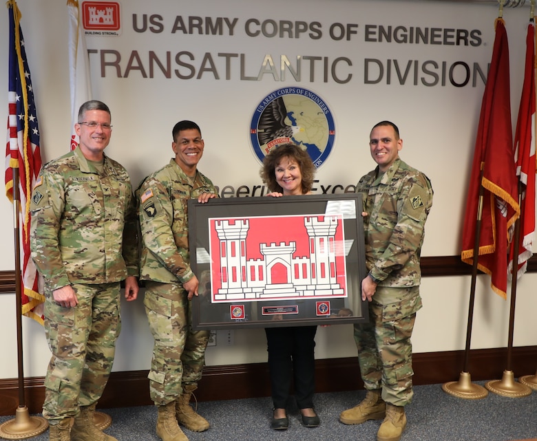 Members of the Transatlantic Division Command Team present a “farewell” gift from TAD employees to Joan Kibler on the occasion of her “re-retirement.” Kibler was a “reemployed annuitant” – a former federal civil servant who came out of retirement to support TAD’s Public Affairs office. She retired March 19, 2019, for what she promises is the last time, after 40 years in public service. Pictured (left to right) are Col. Scott Lowdermilk, TAD Commander Col. Mark C. Quander, Kibler, and TAD Command Sergeant Major Randolph Delapena.
