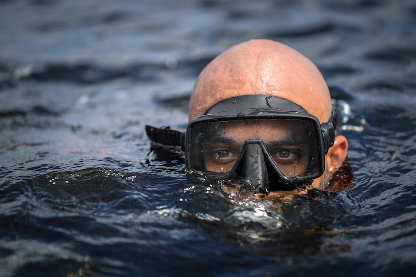 A male diver emerges from water.