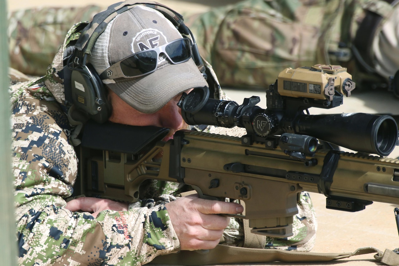 A service member aims a rifle.