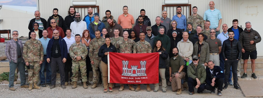 Members of the U.S. Army Corps of Engineers Transatlantic Division's Task Force Mosul Dam, headquartered in Iraq, pose in front of their building. The team was presented with an award for voting their organization a one of the "Best Places To Work" in the Federal Government.