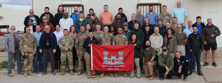 Members of the U.S. Army Corps of Engineers Transatlantic Division's Task Force Mosul Dam, headquartered in Iraq, pose in front of their building. The team was presented with an award for voting their organization a one of the "Best Places To Work" in the Federal Government.