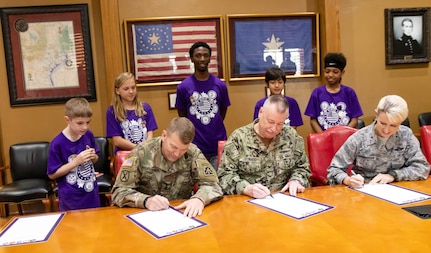 Joint Base San Antonio leaders recognized the contributions of military children and families during a proclamation ceremony designating April as Month of the Military Child at JBSA-Fort Sam Houston March 29. The ceremony was held in the Texas Room at the U.S. Army North (Fifth Army) Headquarters. Signing the proclamation were (from left)  Lt. Gen. Jeffrey Buchanan, ARNORTH commanding general; Capt. William Leonard, Navy Medicine Education and Training Command deputy commander; and Brig. Gen. Laura L. Lenderman, JBSA and 502nd Air Base Wing commander. Also attending the proclamation signing were five students from the Fort Sam Houston Independent School District and their parents.
