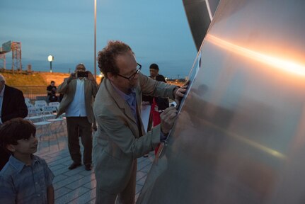 George Schroeder, designer, autographs posters of the Tribute to Freedom sculpture grand opening, Mar. 27, 2019, at the corner of U.S. Highway 90 and Military Drive.