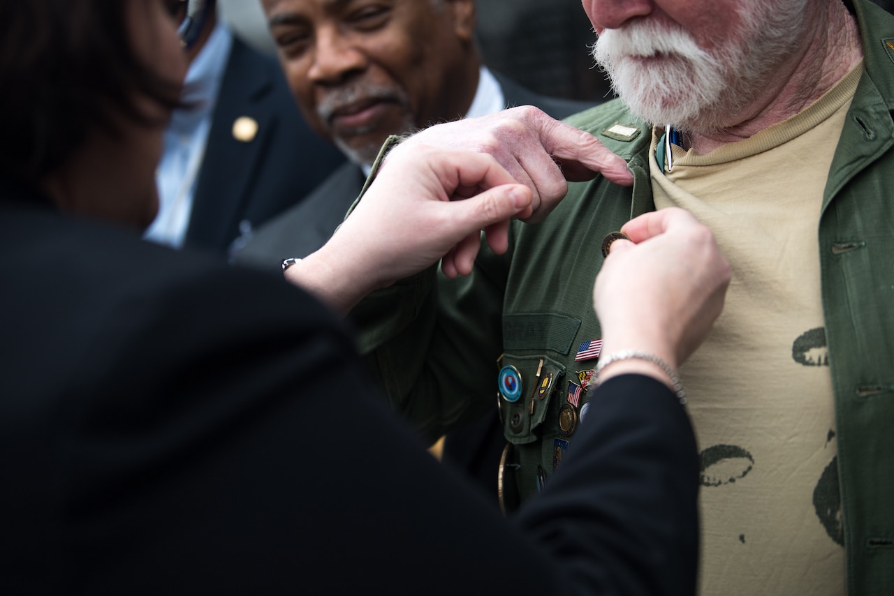 Woman pins lapel pin on man