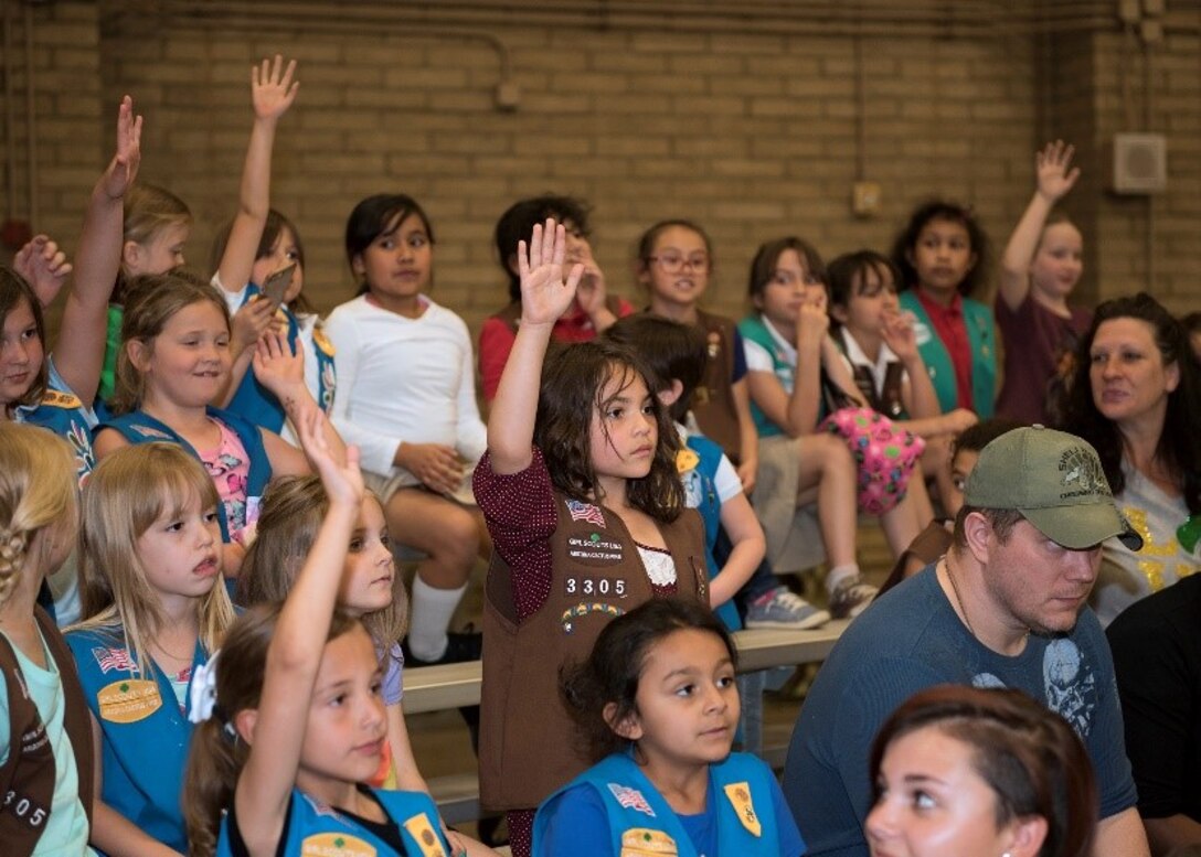 Girl Scouts raise their hands to ask questions to a panel of four female Airmen at Luke Air Force Base, Ariz., March 27, 2019. The panel spoke to over a hundred Girl Scouts and answered questions about their jobs, experiences and obstacles they have overcome to reach their current position. (U.S. Air Force photo by Airman 1st Class Leala Marquez)