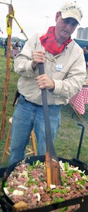 Andrew Robinson, with the 1298 C&C chuckwagon out of Fort Worth, Texas, stirs meat and veggies for a delicious Texas goulash at the annual Cowboys for Heroes chuckwagon event at Joint Base San Antonio-Fort Sam Houston March 30.