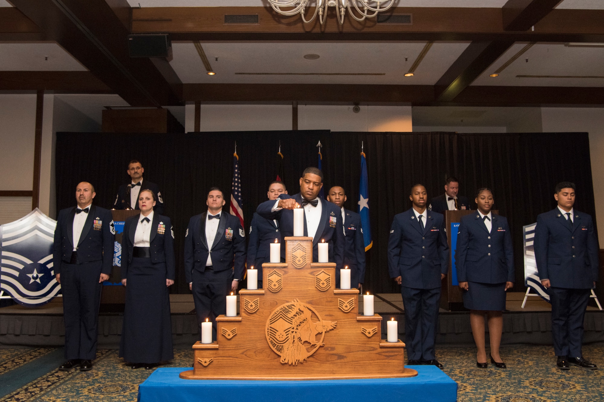 U.S. Air Force Chief Master Sgt. Phillip L. Easton, U.S. Air Forces in Europe and Africa command chief, lights the final candle in a traditional candle-lighting ceremony during the Chief Recognition Ceremony on Ramstein Air Base, March 23, 2019. The candle-lighting portion of the ceremony signifies the importance every rank contributes to propel the mission forward. (U.S. Air Force photo by Airman 1st Class Kristof J. Rixmann)