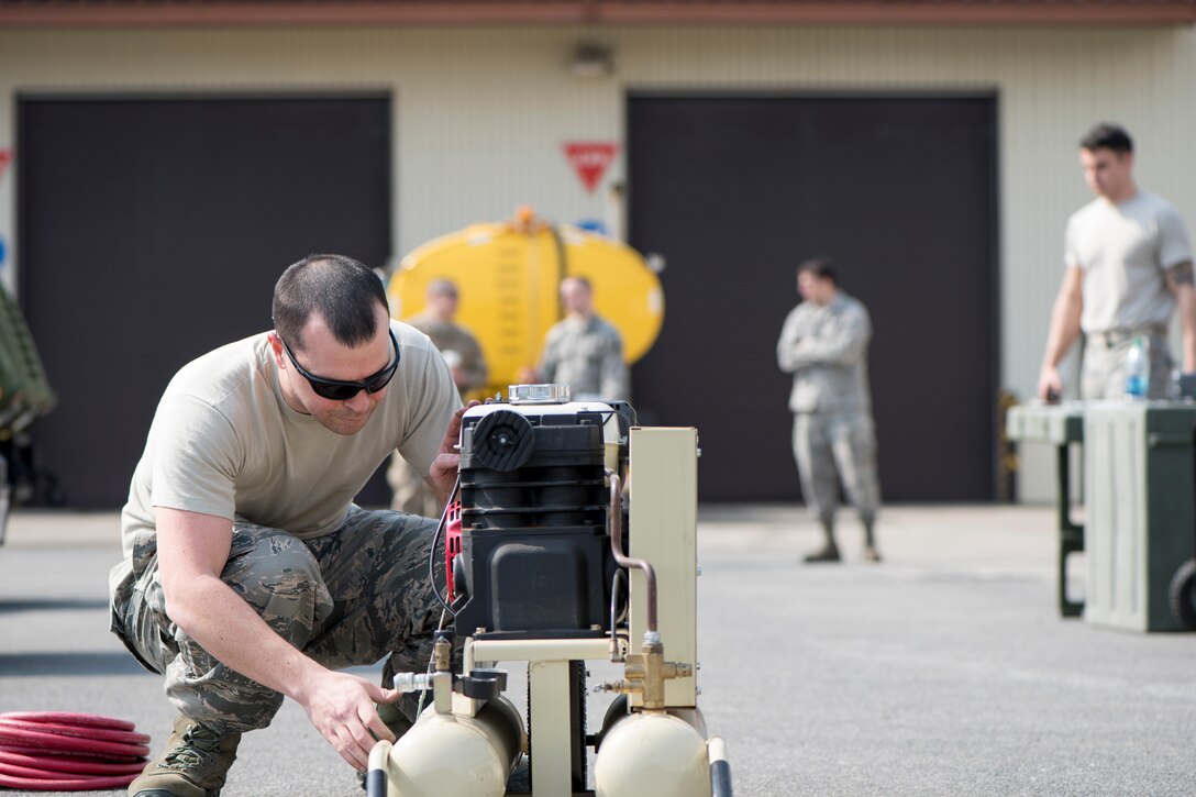 U.S. Air Force Tech. Sgt. Garrett Dicus, the 35th Logistics Readiness Squadron multiple maintenance section chief, inspects an air compressor  during the first LRS Agile Combat Employment exercise at Misawa Air Base, Japan, March 20, 2019. Airmen were only allowed to use a limited amount of mechanical tools such as standard car jacks, fuses, light bulbs, and a generator testing their innovation and personal skillset during an unexpected contingency operations. (U.S. Air Force photo by Airman 1st Class Collette Brooks)