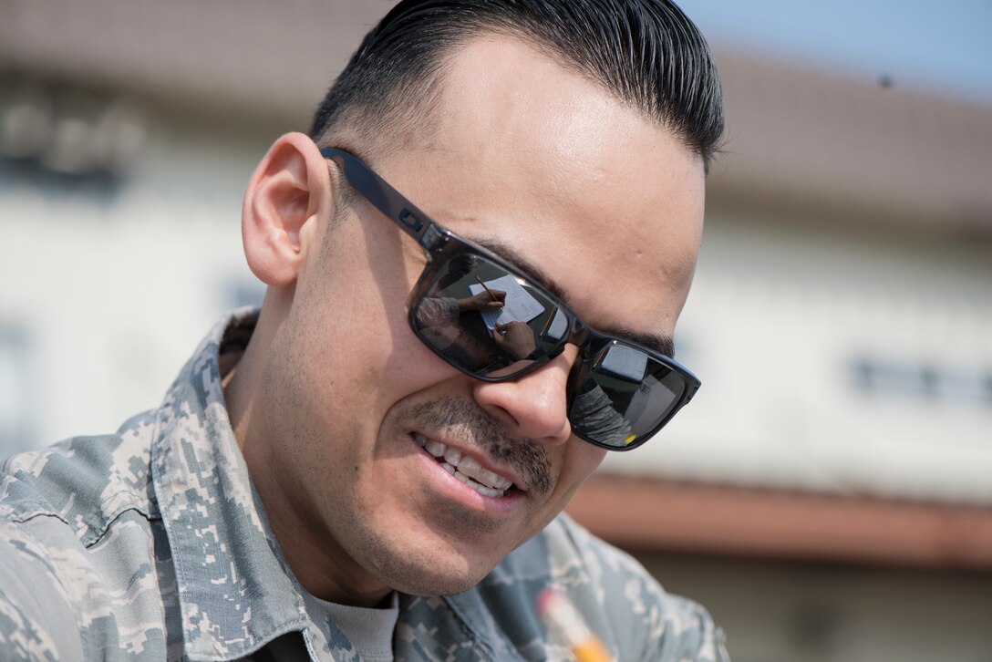 U.S. Air Force Staff Sgt. Adrian Torrez, the 35th Logistic Readiness Squadron light duty vehicle NCO in charge, writes on a vehicle maintenance ticket during the first LRS Agile Combat Employment exercise at Misawa Air Base, Japan, March 20, 2019. A job ticket details what mechanical issues mechanics need to service on an inoperable motor vehicle. (U.S. Air Force photo by Airman 1st Class Collette Brooks)