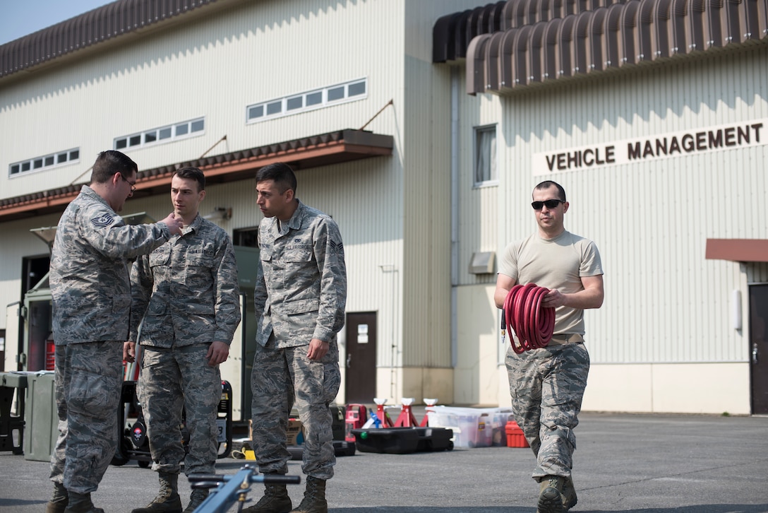 Airmen with the 35th Logistic Readiness Squadron discuss operations and move materials during the first LRS Agile Combat Employment exercise at Misawa Air Base, Japan, March 20, 2019. The exercise challenged the Airmen to determine the tools that were absolutely critical to completing the vehicle operations mission, ensuring that no space is wasted when preparing for contingency relocation operations. (U.S. Air Force photo by Airman 1st Class Collette Brooks)