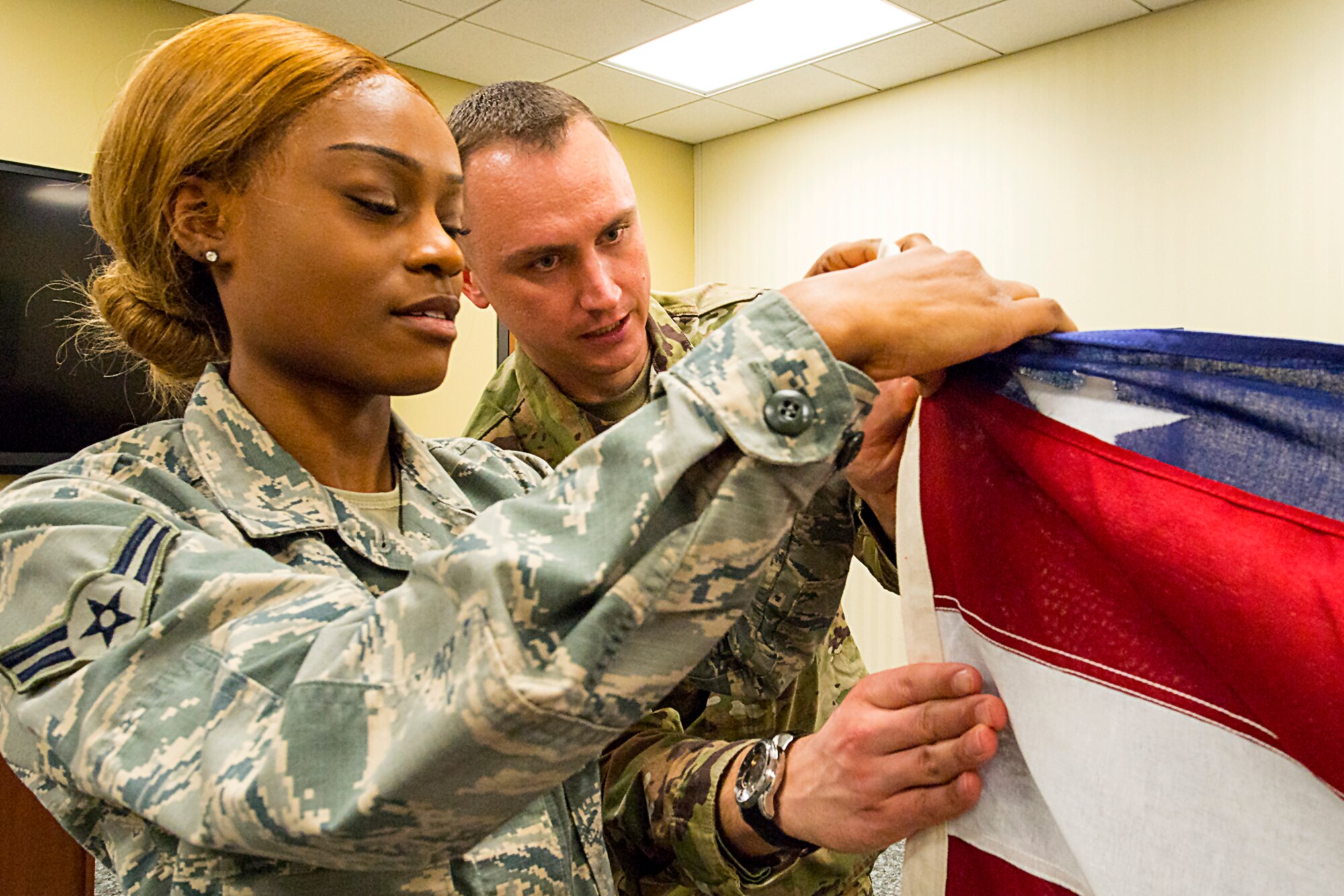 Airman 1st Class Alexis Cockle, a services apprentice with the 434th Force Support Squadron, receives training from Master Sgt. Adam Reynolds, Honor Guard program manager, on proper flag folding techniques during a training class held March 29, 2019 at Grissom. The Honor Guard is working to expand membership to support a variety of details. (U.S. Air Force photo/Douglas Hays)