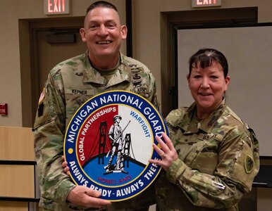 Command Sgt. Maj. Christopher Kepner receives a Michigan National Guard coin from Command Sgt. Maj. Catherine Farrell at the Michigan National Guard Joint Junior Leadership Conference held April 24-26, 2019, at Alpena Combat Readiness Training Center. This is the first time both Michigan Air and Army National Guard members, ranks E1-E6, have joined to attend a professional development event like this.