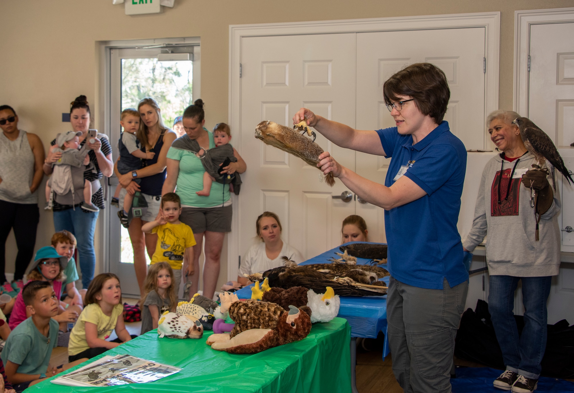 Julie Cotton, outreach coordinator with the California Raptor Center, demonstrates the gripping action of a bird of prey, during a presentation on local raptors, April 24, 2019, at Travis Air Force Base, California. As part of the Earth Day event, participants were educated on raptor biology, rehabilitation, conservation and species identification during the CRC visit. (U.S. Air Force photo by Heide Couch)