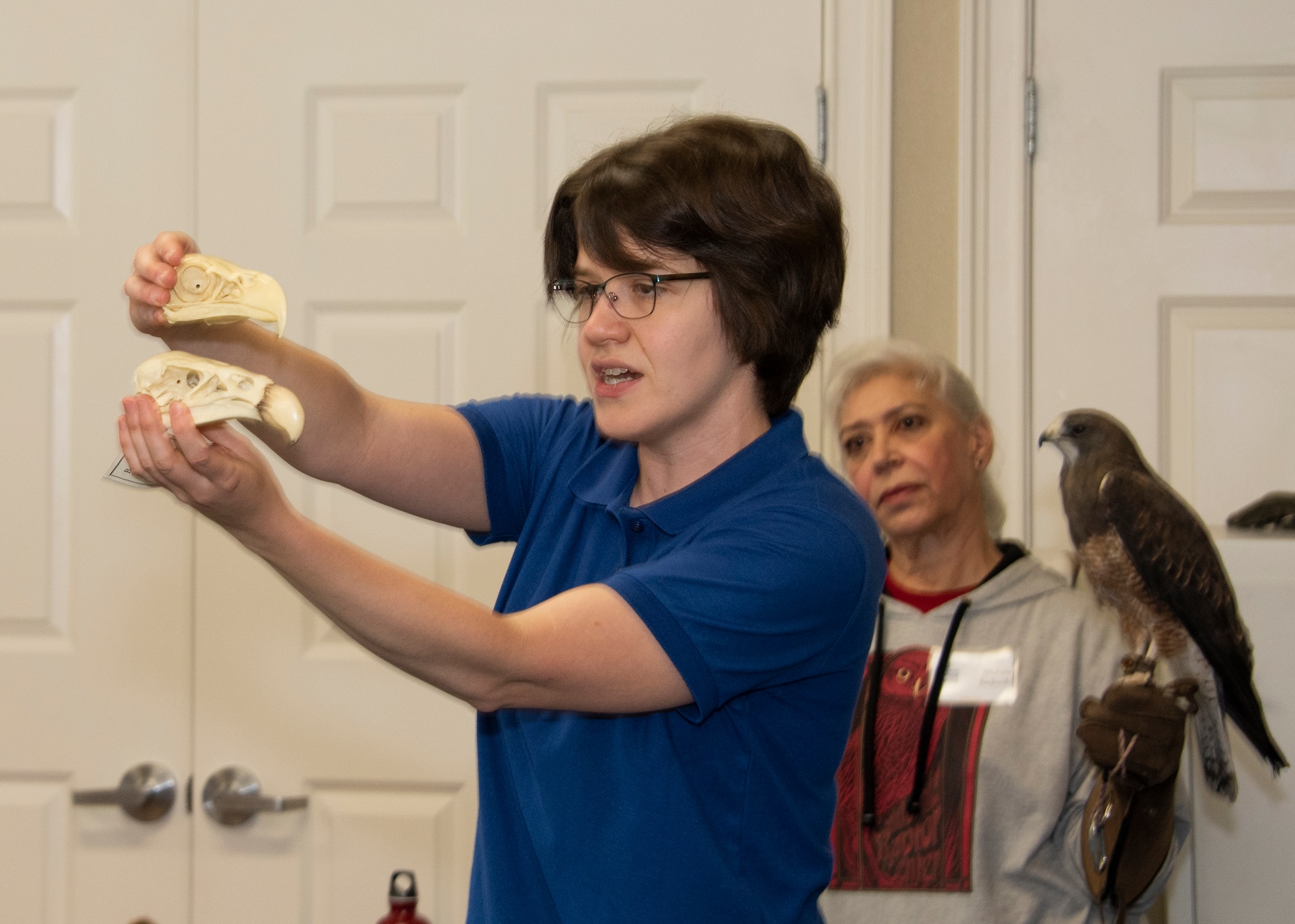 Julie Cotton, an outreach coordinator with the California Raptor Center, displays the skulls of two different birds of prey during a presentation on local raptors, April 24, 2019, at Travis Air Force Base, California. As part of the Earth Day event, participants were educated on raptor biology, rehabilitation, conservation and species identification during the CRC visit. (U.S. Air Force photo by Heide Couch)