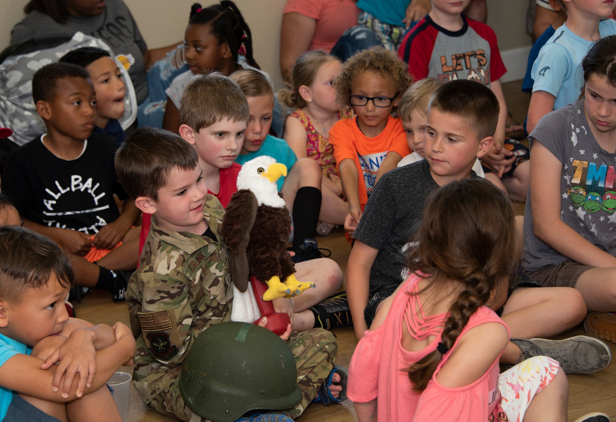 Children pass around a “bald eagle” plush toy designed to weigh the same as the real bird, April 24, 2019, at Travis Air Force Base, California. As part of the Earth Day event presented by the California Raptor Center, participants were educated on raptor biology, rehabilitation, conservation and species identification. (U.S. Air Force photo by Heide Couch)