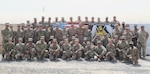 Soldiers of the 420th Transportation Battalion, a U.S. Army movement control battalion, gather at their memorial T-Wall at Camp Arifjan, Kuwait, April 27, 2019.