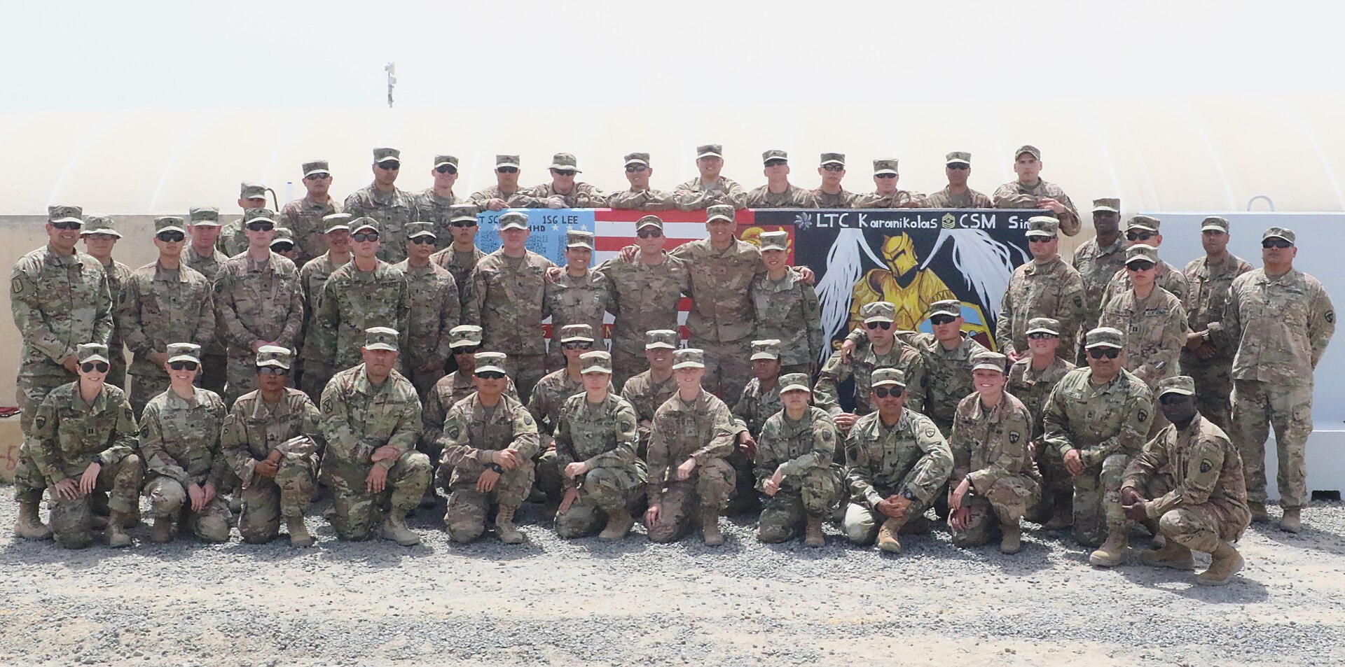 Soldiers of the 420th Transportation Battalion, a U.S. Army movement control battalion, gather at their memorial T-Wall at Camp Arifjan, Kuwait, April 27, 2019.