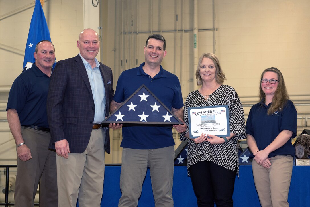 Airman receiving retirement flag and certficate.