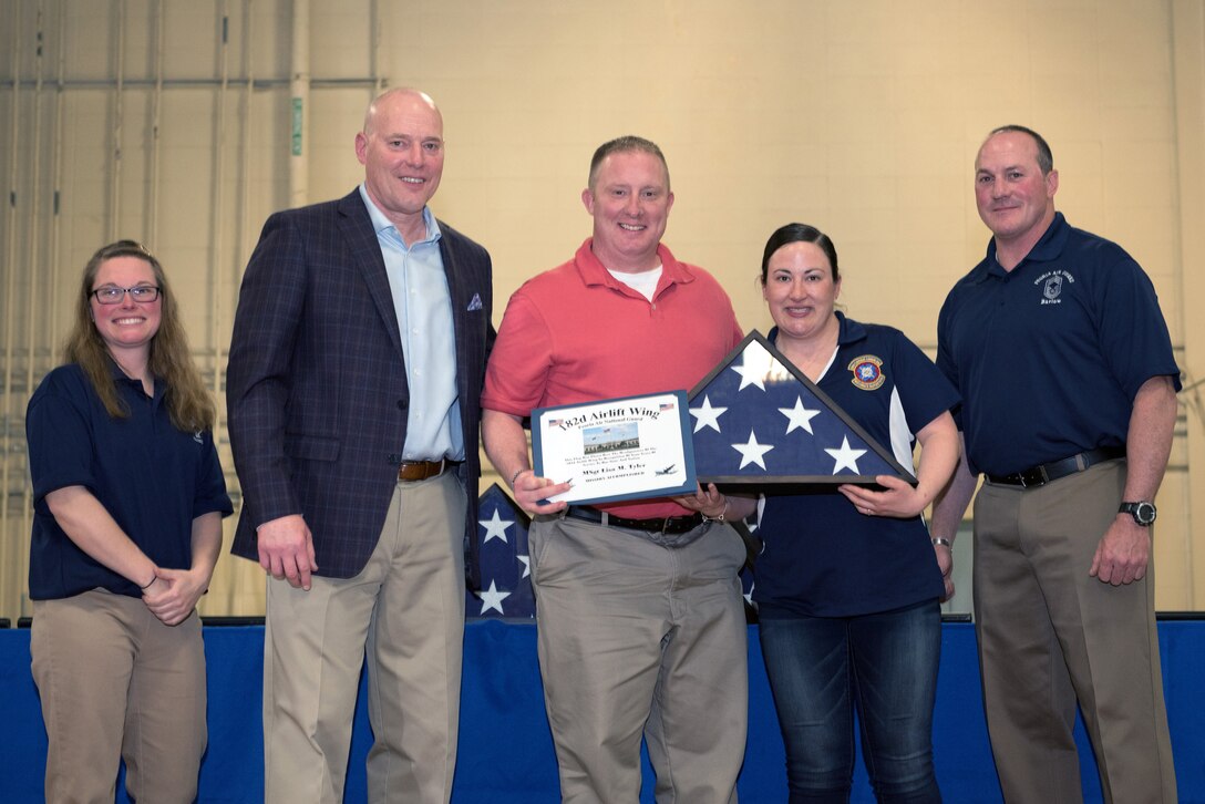 Airman receiving retirement flag and certficate.