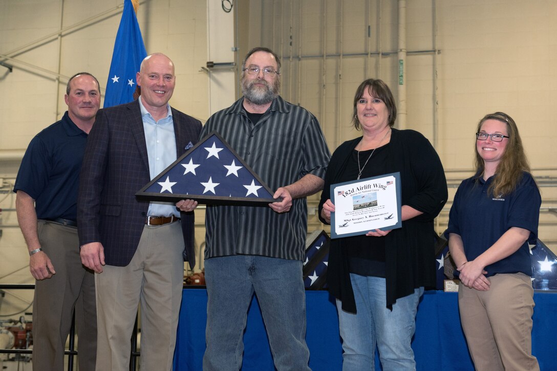 Airman receiving retirement flag and certificate.