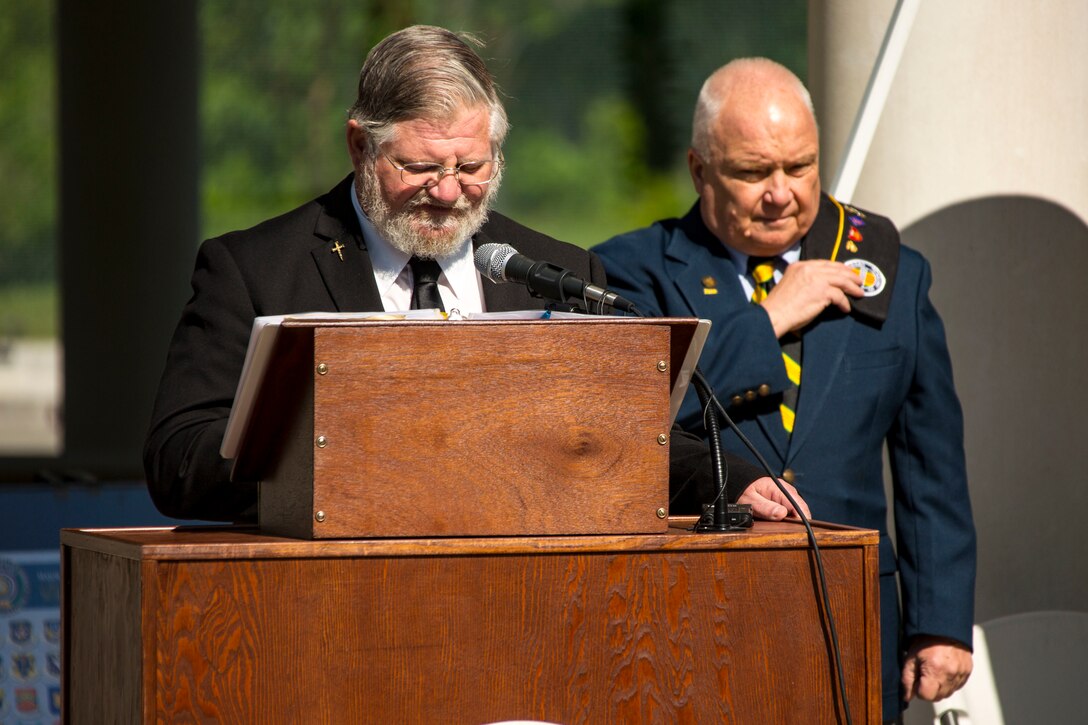 Retired U.S. Marine Corps Gunnery Sgt. Raymond J. Randall, left, delivers the opening invocation while retired Sgt. Maj. Paul W. Siverson, veterans outreach program specialist, bows his head during the Vietnam Veterans Recognition Day Ceremony at the Onslow Vietnam Veterans Memorial, Lejeune Memorial Gardens, Jacksonville, North Carolina, April 27, 2019. The ceremony honored the memory of those who died during the war and celebrated the accomplishments and perseverance of Vietnam-era veterans. (U.S. Marine Corps Photo by Lance Cpl. Isaiah Gomez)