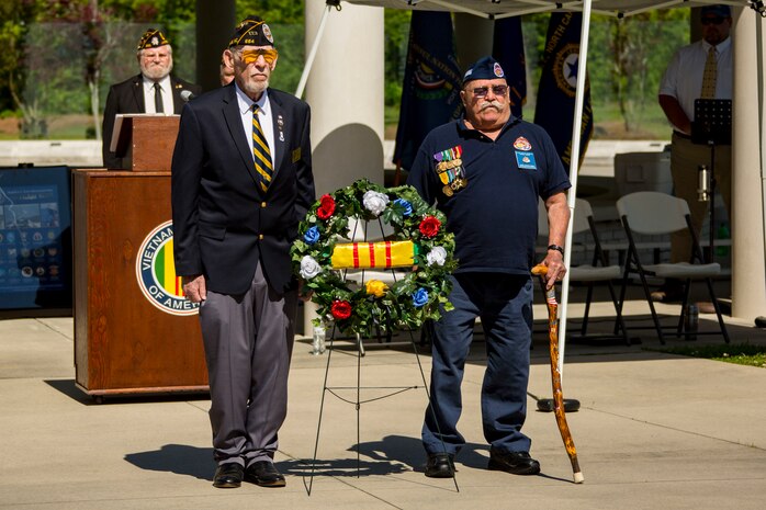 Retired U.S. Navy Petty Officer 1st Class, Michael E. Carr, left, Vietnam Veteran Association Chapter 654 president, and retired U.S. Coast Guard Petty Officer 1st Class, Floyd C. Hampton, right, Coast Guard Combat Veterans Association service officer, stand at attention during the Vietnam Veterans Recognition Day Ceremony at the Onslow Vietnam Veterans Memorial, Lejeune Memorial Gardens, Jacksonville, North Carolina, April 27, 2019. The ceremony honored the memory of those who died during the war and celebrated the accomplishments and perseverance of Vietnam-era veterans. (U.S. Marine Corps Photo by Lance Cpl. Isaiah Gomez)