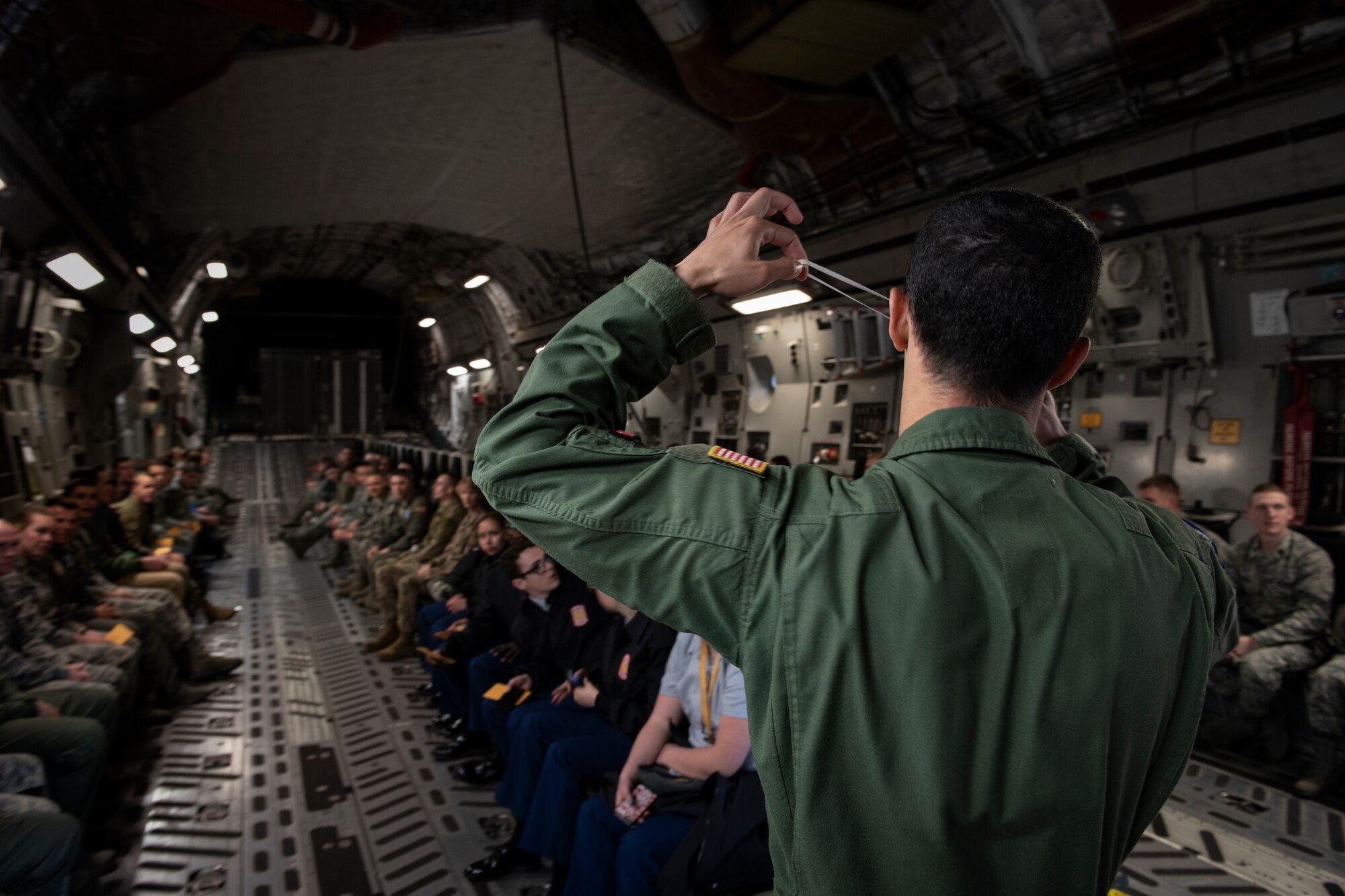 Staff Sgt. Nelson Jones, a loadmaster assigned to the 58th Airlift Squadron, shows ROTC cadets how to properly apply safety gear in case of an emergency, April 20, 2019, Provo, Utah. Jones was a member of a five-man crew operating the flight. (U.S. Air Force photo by Airman 1st Class Jeremy Wentworth)