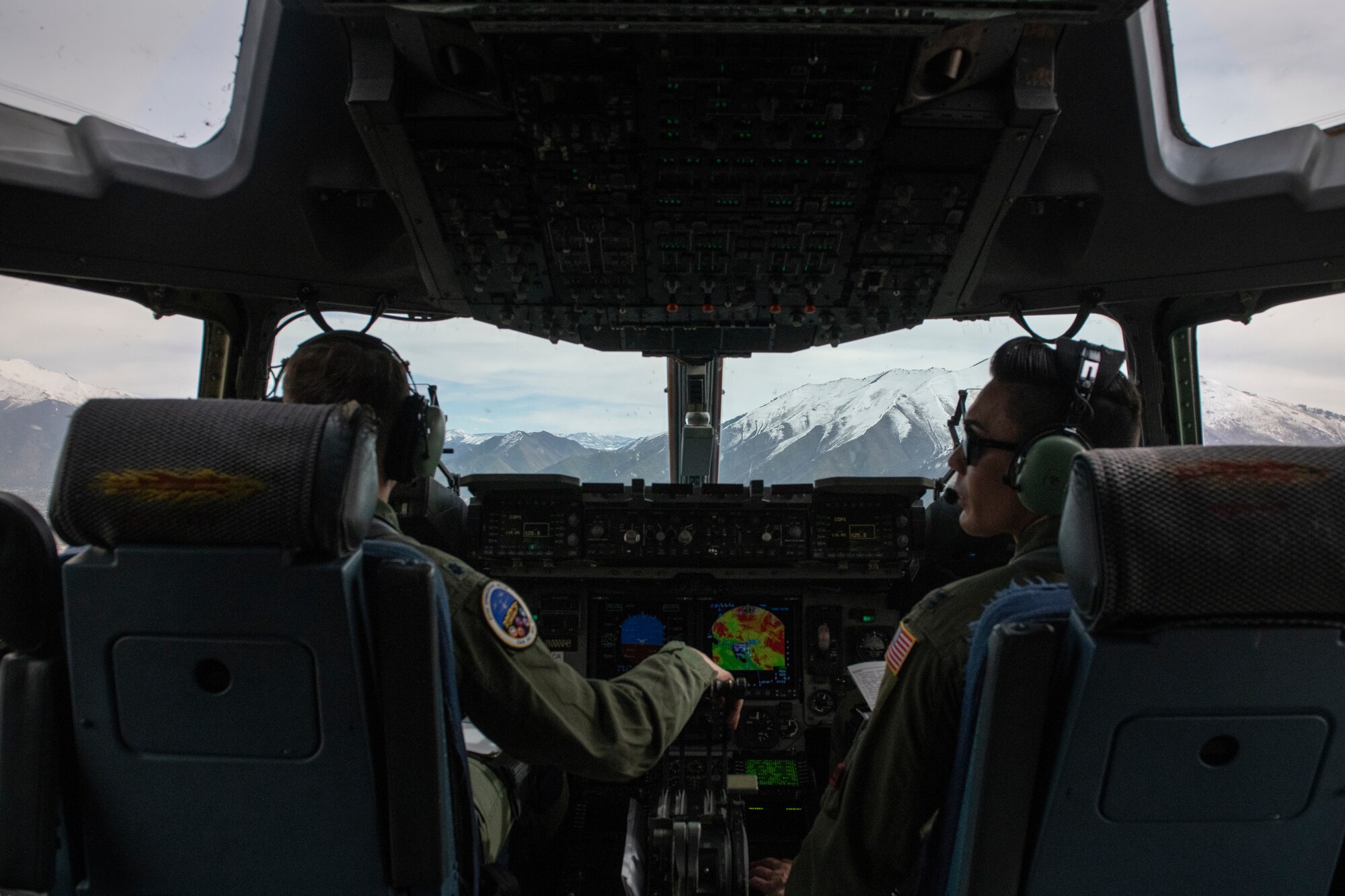 Lt. Col. Chris Haines, commander of the 97th Operations Group, and Capt. Justin Gross, a C-17 pilot assigned to the 58th Airlift Squadron, fly over mountains in Utah during an incentive flight, April 20, 2019, Provo, Utah. The flight was given to cadets who were interested in a future in aviation with the Air Force. (U.S. Air Force photo by Airman 1st Class Jeremy Wentworth)