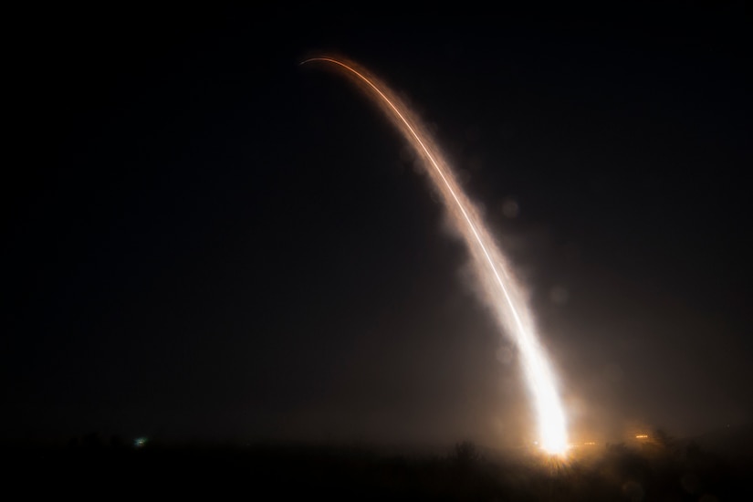 The fiery trail of a missile lights up a dark sky.