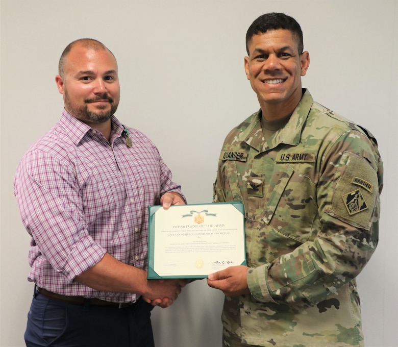 TAD Commander Col. Mark C. Quander, presents the Civilian Service Commendation Medal to Bahrain Program Manager Peter DeMattei, during a ceremony held at the TAD headquarters in Winchester, Va., on April 25, 2019. Quander lauded DeMattei for his work performance leading the Bahrain Project Deliver Team.